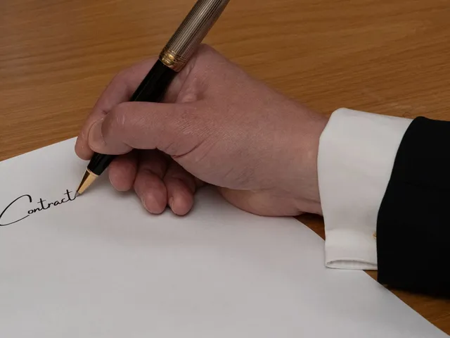 Podpisywanie umowy piórem przy biurku